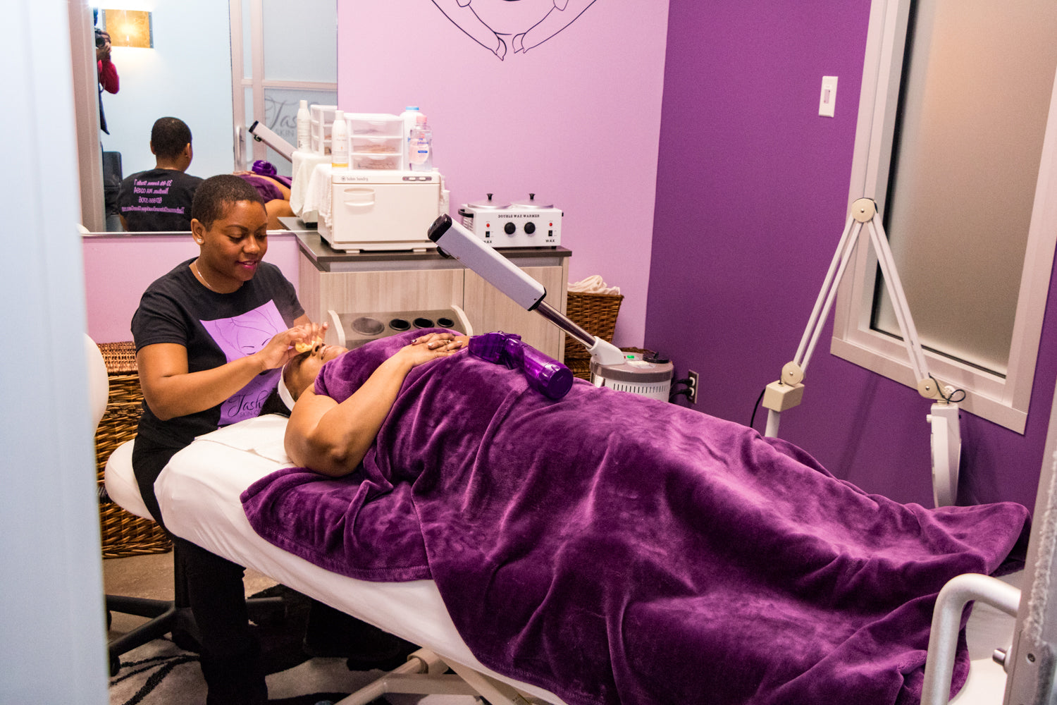 Person receiving a treatment on a purple draped table in a clinical setting.